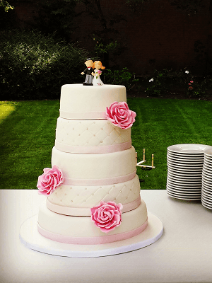 5 Laags witte bruidstaart met roze rozen en bruidspaar