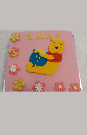 Roze verjaardagstaart met een tekening van winnie de pooh