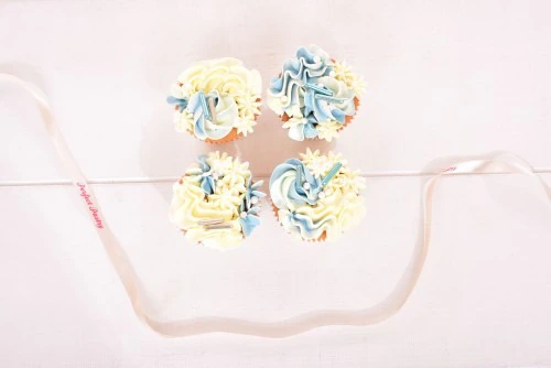 Baby shower cupcakes jongen blauw-en-witte-botercreme-cupcakes-met-blauw-decoraties-baby-shower-jongen