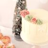 witte-kerst-drip-taart-met-roze-en-mint-groen-bloemen