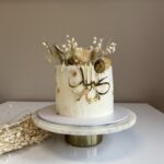 Luxe witte Suikerfeest taart met gouden Eid Mubarak acryl topper en droogbloemen, gemaakt door Perfect Pastry