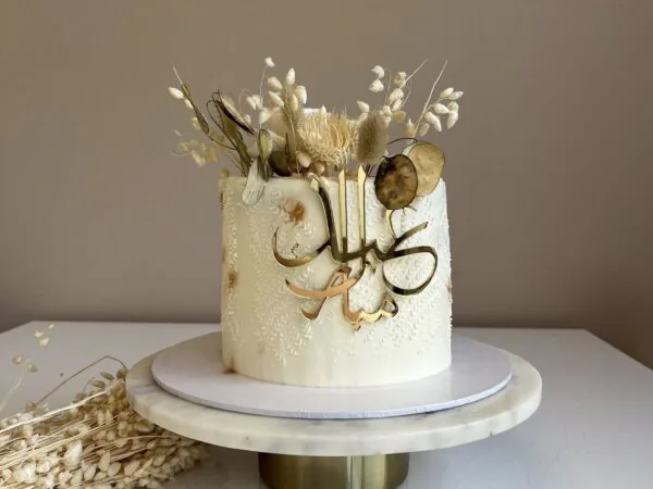 Luxe witte Suikerfeest taart met gouden Eid Mubarak acryl topper en droogbloemen, gemaakt door Perfect Pastry